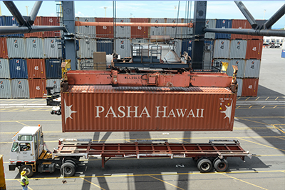 Pasha Hawaii's team loading a shipping container onto a chassis for delivery