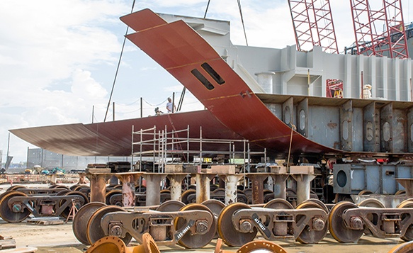 A worker works on the side panels of the Pasha Hawaii Shipping Container vessel